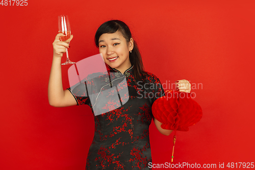 Image of Happy Chinese New Year. Asian young girls\'s portrait isolated on red background