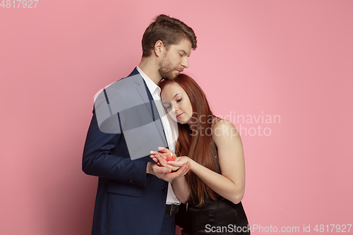 Image of Valentine\'s day celebration, happy caucasian couple isolated on coral background