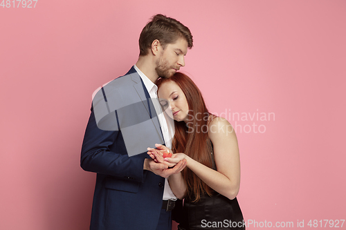 Image of Valentine\'s day celebration, happy caucasian couple isolated on coral background