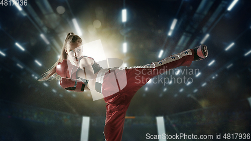 Image of Young female kickboxing fighter training in the gym