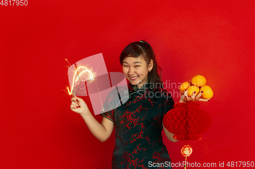 Image of Happy Chinese New Year. Asian young girls\'s portrait isolated on red background