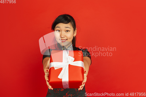 Image of Happy Chinese New Year. Asian young girls\'s portrait isolated on red background