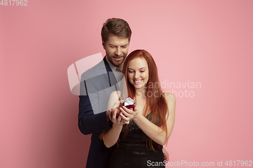 Image of Valentine\'s day celebration, happy caucasian couple isolated on coral background