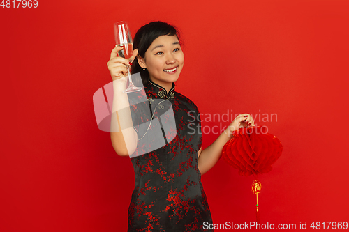 Image of Happy Chinese New Year. Asian young girls\'s portrait isolated on red background