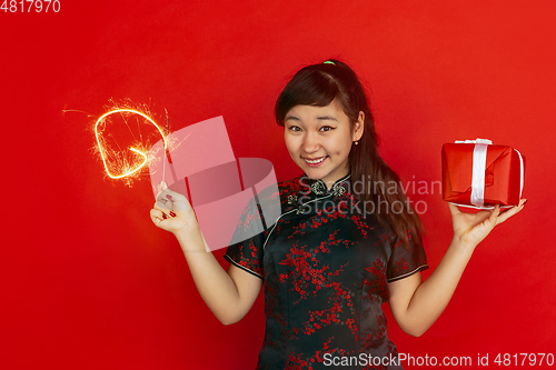 Image of Happy Chinese New Year. Asian young girls\'s portrait isolated on red background