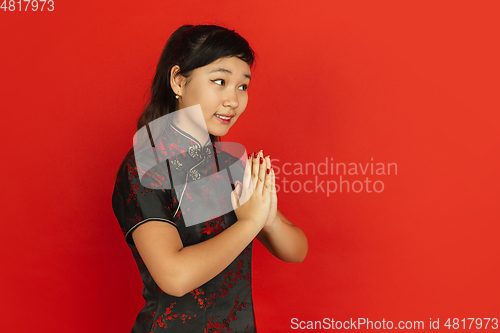 Image of Happy Chinese new year. Asian young girls\'s portrait isolated on red background