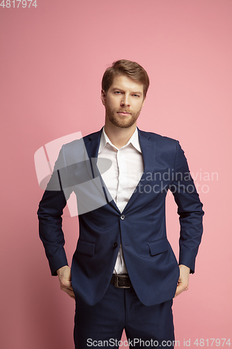 Image of Portrait of young caucasian man isolated on coral background