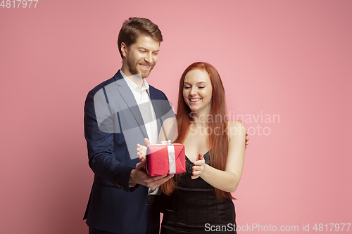 Image of Valentine\'s day celebration, happy caucasian couple isolated on coral background