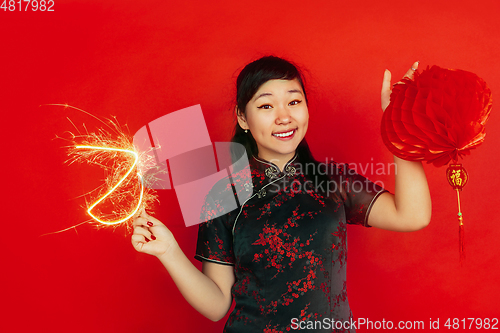 Image of Happy Chinese New Year. Asian young girls\'s portrait isolated on red background