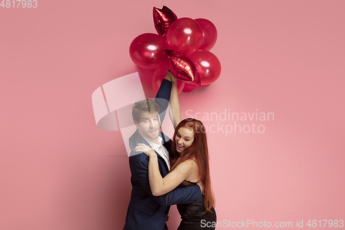 Image of Valentine\'s day celebration, happy caucasian couple isolated on coral background