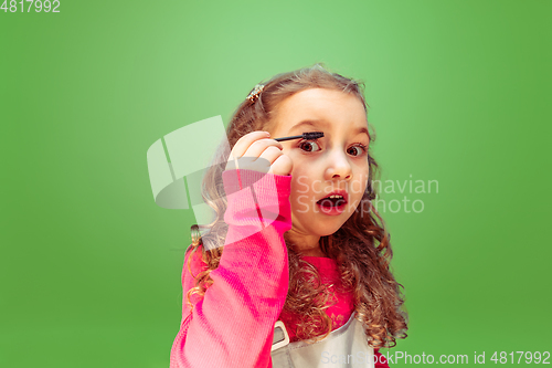 Image of Little girl dreaming about future profession of makeup artist