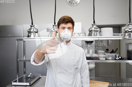 Image of male chef with in respirator at restaurant kitchen