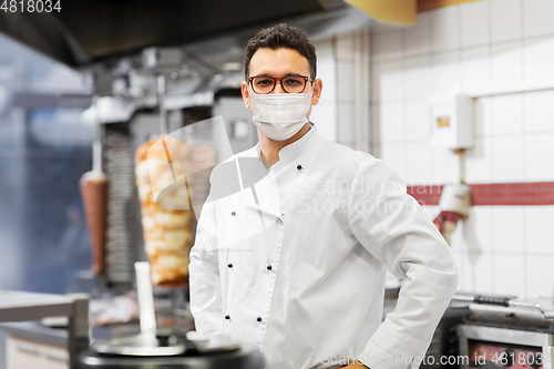 Image of male chef with in face mask at kebab shop kitchen