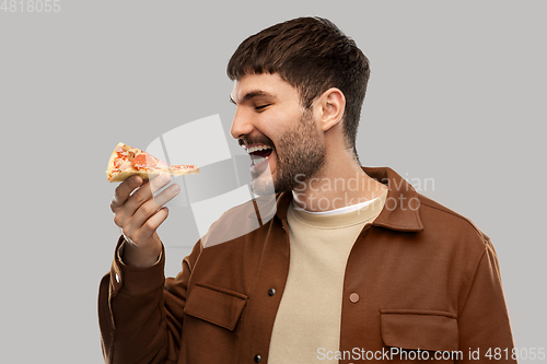 Image of happy smiling young man eating pizza