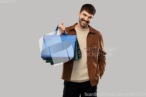 Image of happy smiling young man with shopping bags