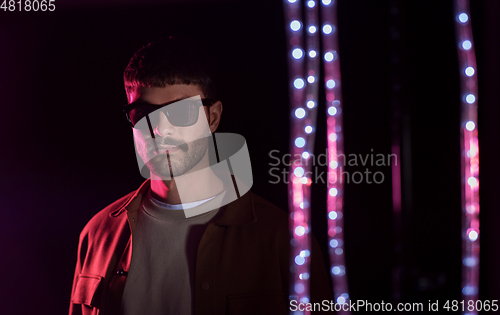 Image of man in sunglasses over neon lights at nightclub