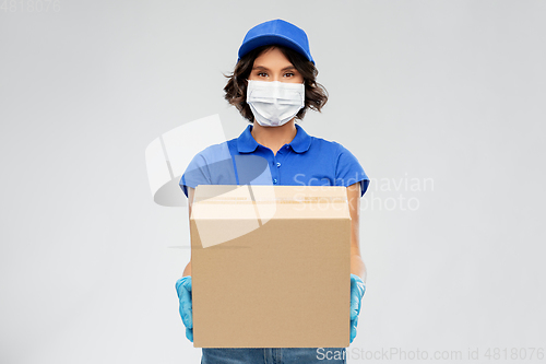 Image of delivery woman in face mask holding parcel box