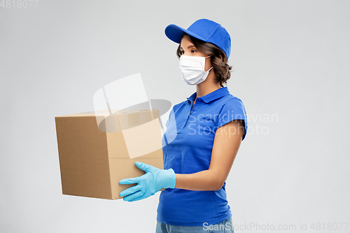 Image of delivery woman in face mask holding parcel box