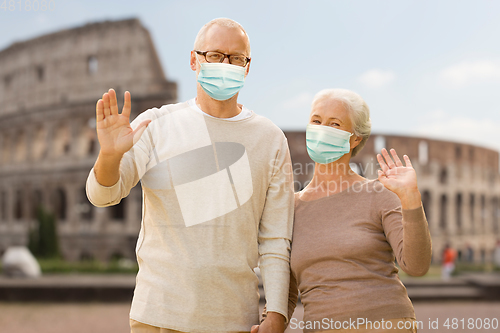 Image of senior couple in protective medical masks in italy