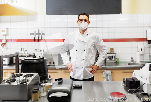 Image of male chef with in face mask at restaurant kitchen