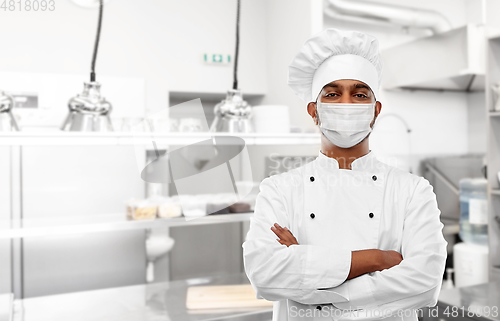 Image of male chef in face mask at restaurant kitchen