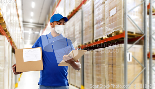 Image of delivery man in mask with parcel box and clipboard