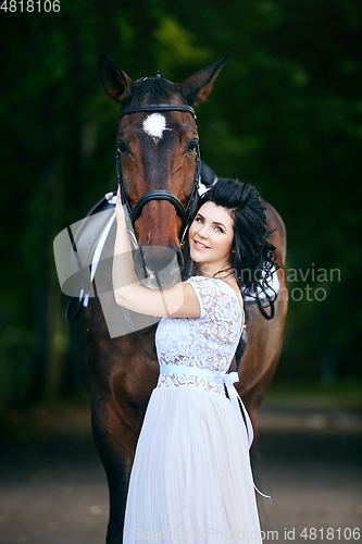 Image of beautiful girl in dress with horse