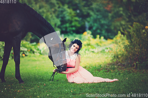 Image of beautiful girl in dress with horse