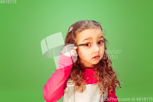 Image of Little girl dreaming about future profession of makeup artist