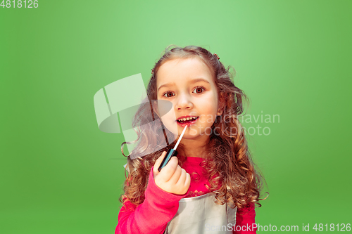 Image of Little girl dreaming about future profession of makeup artist