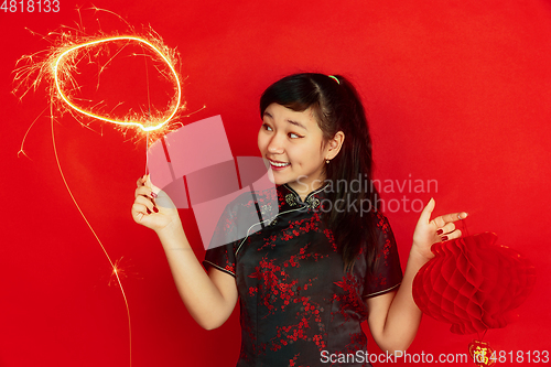 Image of Happy Chinese New Year. Asian young girls\'s portrait isolated on red background