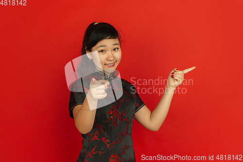 Image of Happy Chinese new year. Asian young girls\'s portrait isolated on red background