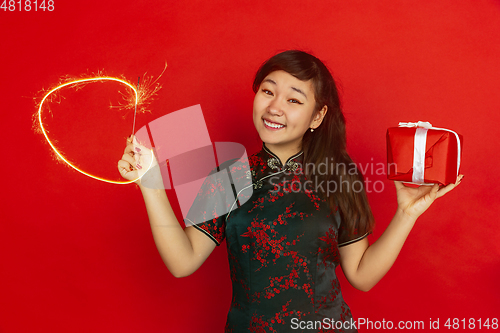 Image of Happy Chinese New Year. Asian young girls\'s portrait isolated on red background