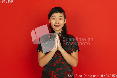 Image of Happy Chinese new year. Asian young girls\'s portrait isolated on red background