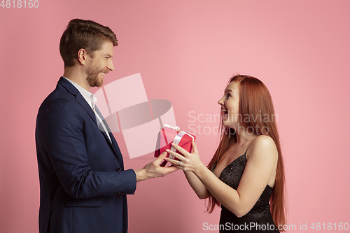 Image of Valentine\'s day celebration, happy caucasian couple isolated on coral background