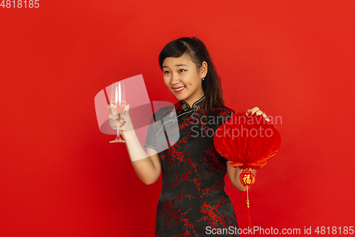 Image of Happy Chinese New Year. Asian young girls\'s portrait isolated on red background