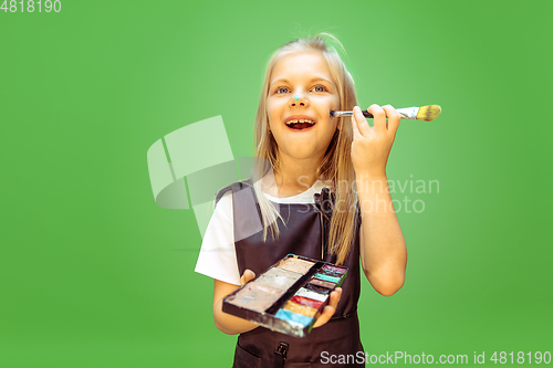 Image of Little girl dreaming about future profession of makeup artist