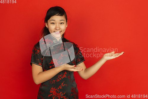 Image of Happy Chinese new year. Asian young girls\'s portrait isolated on red background