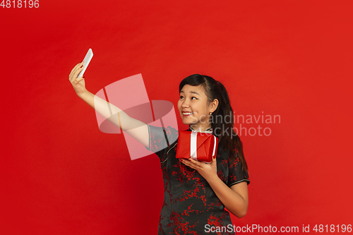 Image of Happy Chinese New Year. Asian young girls\'s portrait isolated on red background