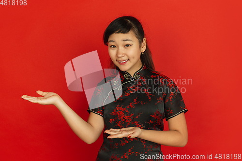 Image of Happy Chinese new year. Asian young girls\'s portrait isolated on red background