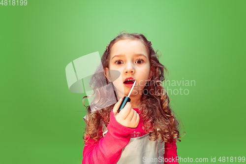 Image of Little girl dreaming about future profession of makeup artist