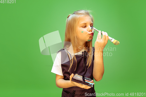 Image of Little girl dreaming about future profession of makeup artist