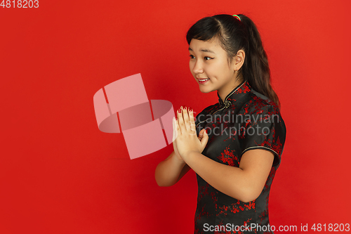 Image of Happy Chinese new year. Asian young girls\'s portrait isolated on red background