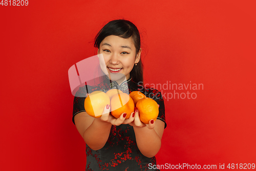 Image of Happy Chinese New Year. Asian young girls\'s portrait isolated on red background