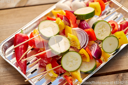 Image of close up of vegetables on skewers on foil grill