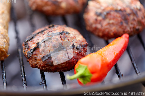 Image of burger meat cutlets and pepper roasting on grill