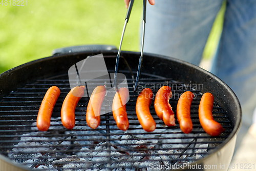 Image of meat sausages roasting on hot brazier grill