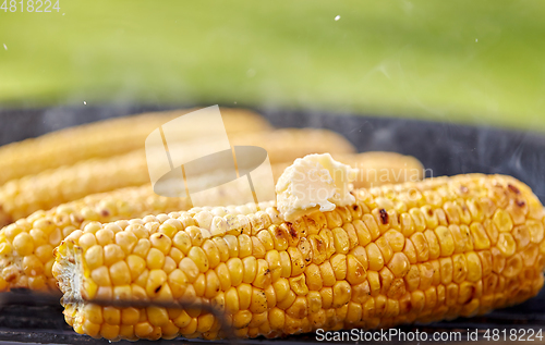 Image of close up of corn with butter roasting on grill
