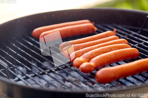 Image of meat sausages roasting on hot brazier grill