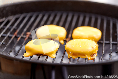 Image of close up of meat cutlet with cheese on grill